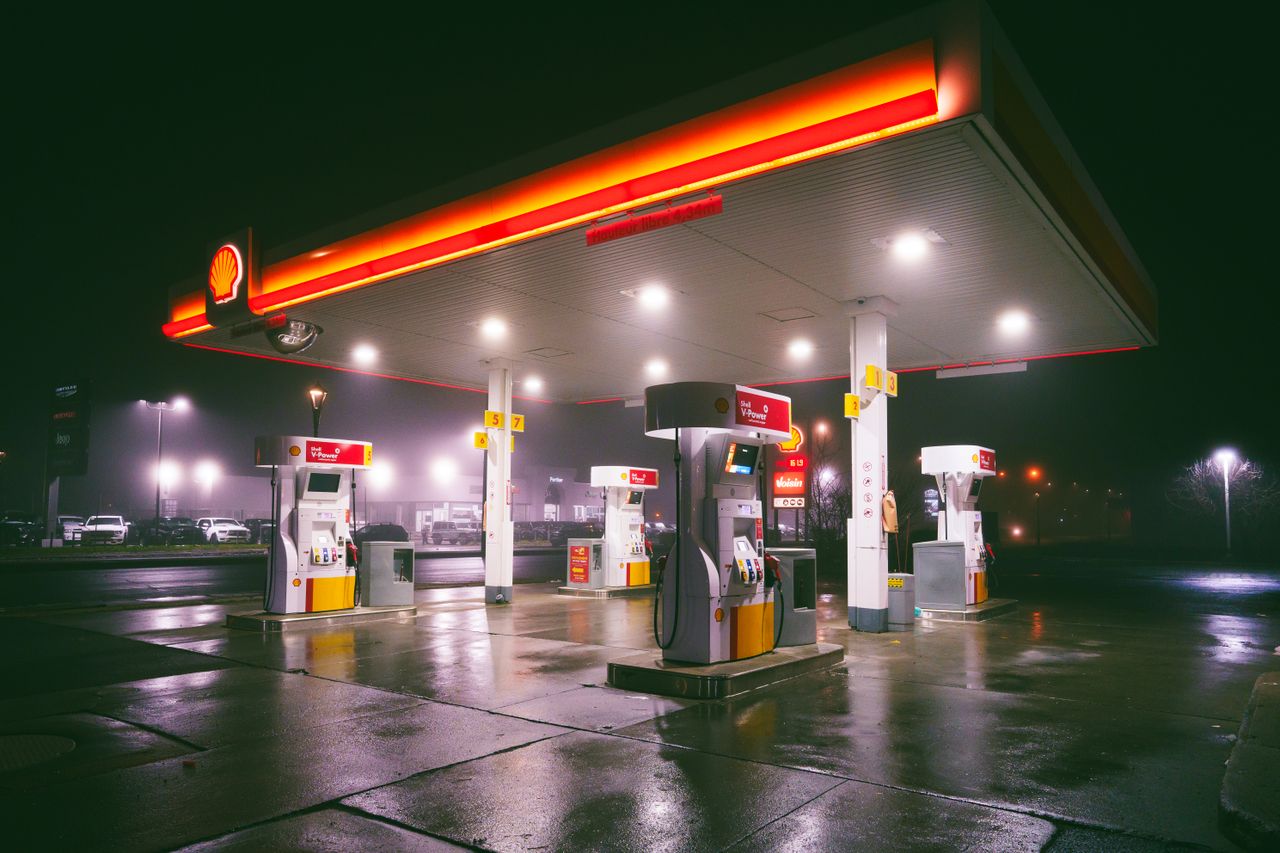 The Art of Drawing Readers In: Your attractive post title goes here A brightly lit gas station on a rainy night with wet reflections on the ground.